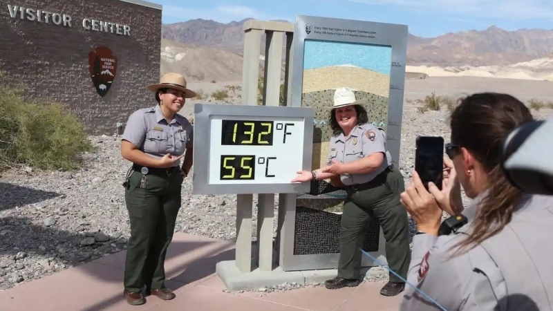 Fotografia dimineții - Două angajate ale parcului național din Valea Morții, California, se fotografiază în dreptul termometrului care arată 55 grade Celsius